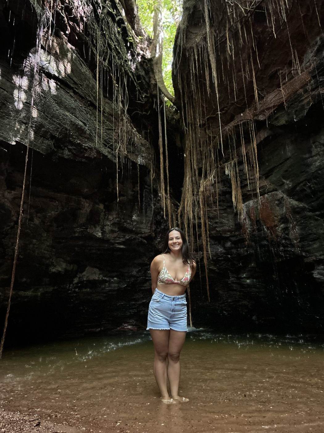 Isadora dentro do Cânion Sussuapara, entre raízes que caem das paredes