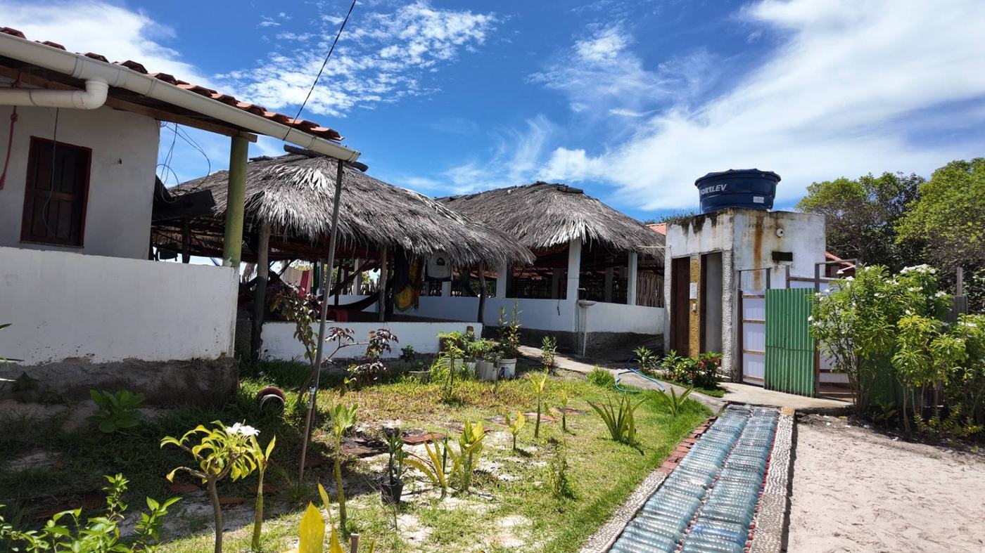 Casa de nativo com telhado de palha entre as dunas